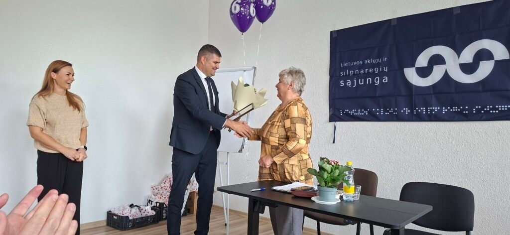 Švenčionių rajono savivaldybės meras Rimantas Klipčius įteikia gėlių puokštę LASS Švenčionių rajono filialo pirmininkei Stasei Mažuolienei.